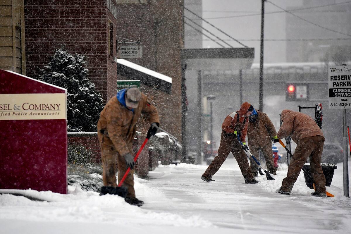 Trabajadores remueven la nieve de las veredas en Johnston, Pensilvania