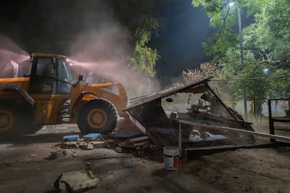 Tractor con pala frontal demoliendo el "centro de jubilados" que funcionaba en Parque Saavedra