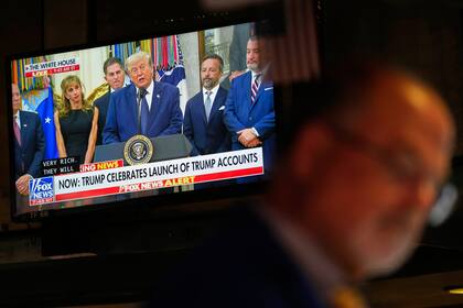 Traders work on the floor of the New York Stock Exchange after United States President Donald Trump, seen on a TV screen, rang the opening bell remotely, in New York, Monday, July 6, 2026. (AP Photo/Seth Wenig)