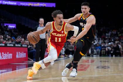 Trae Young, base de los Hawks de Atlant, elude a Grayson Allen, de los Suns de Phoenix, en el encuentro del viernes 2 de febrero de 2024 (AP Foto/John Bazemore)