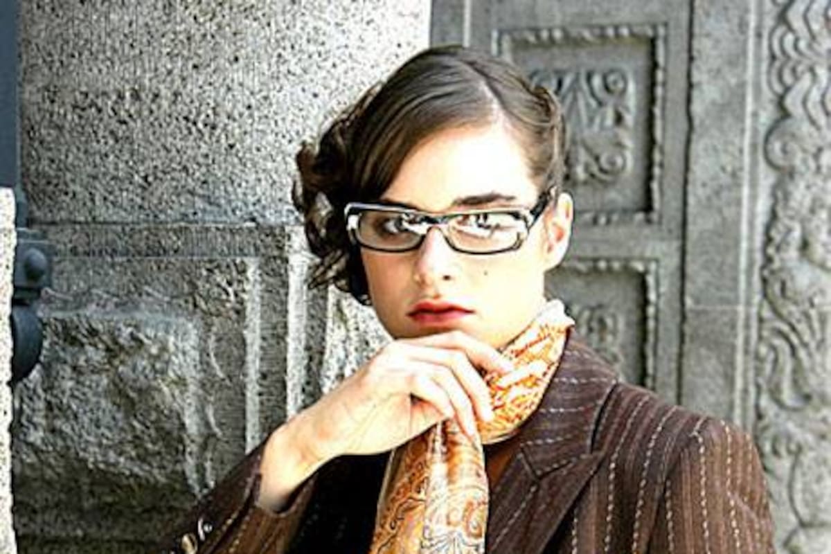 Traje marrón con fantasía y pañuelo con diseños búlgaros (Escada), anteojos de lectura con marco conprint cebra (Teresa Calandra, $ 280)