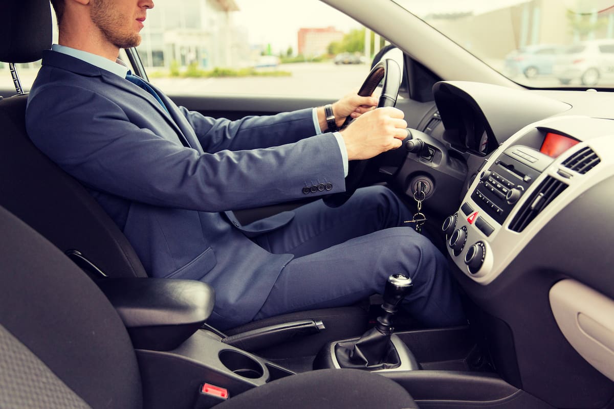 transport, business trip, destination and people concept - close up of young man in suit driving car