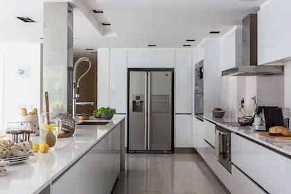 Tras el anafe vitrocerámico de 80cm ($13.239, Cocina on Line), alzada de acero inoxidable coronada por una sintética campana Cata. En ese sector, bol con asas de 18cm ($98 Bazar de la Esquina) y repasador de lino gris ($80, Tienda Fundación Muy Simple)