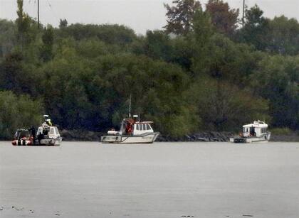 Tres embarcaciones de la Prefectura rastrillaban ayer bajo la lluvia el río Luján