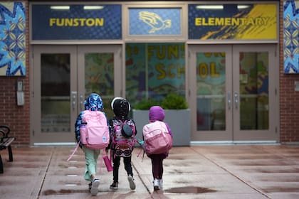 Tres hermanas, cuya madre soltera teme ser detenida por error porque es de ascendencia puertorriqueña y habla español, entran a la escuela Funston Elementary School, en el vecindario Logan Square de Chicago, el 15 de octubre del 2025.