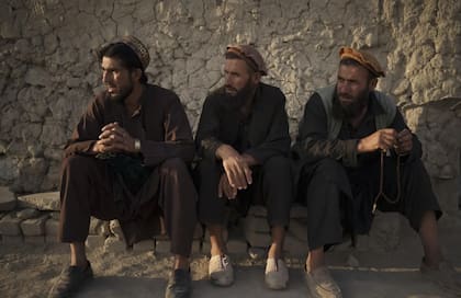 Tres hombres afganos se sientan afuera de una mezquita, el 27 de septiembre de 2021
