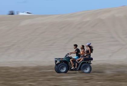 Tres jóvenes circulan por La Hoya (Pinamar) sin casco.