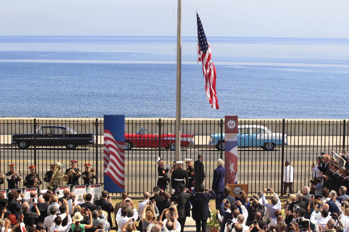 Tres marines izan la bandera de las barras y las estrellas por primera vez desde 1961 en la embajada de Estados Unidos, frente al Malecón de La Habana