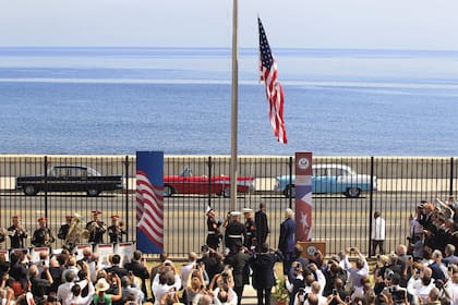 Tres marines izan la bandera de las barras y las estrellas por primera vez desde 1961 en la embajada de Estados Unidos, frente al Malecón de La Habana