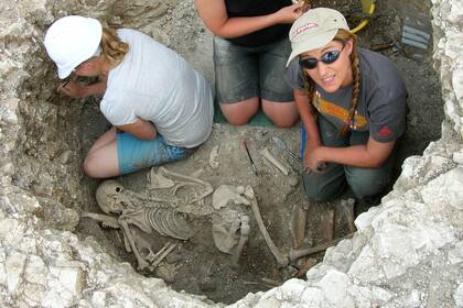 Tres mujeres investigan entierros en un cementerio celta de la Edad del Hierro, parte del proyecto de excavación de la tribu Durotriges en Dorset, en el suroeste de Inglaterra
