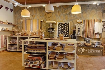 Tres piezas claves para comprar: un camino de mesa en telar mapuche, un matrón tejido y una fuente de madera tallada, una pieza simple, funcional y profundamente conectada al paisaje patagónico.