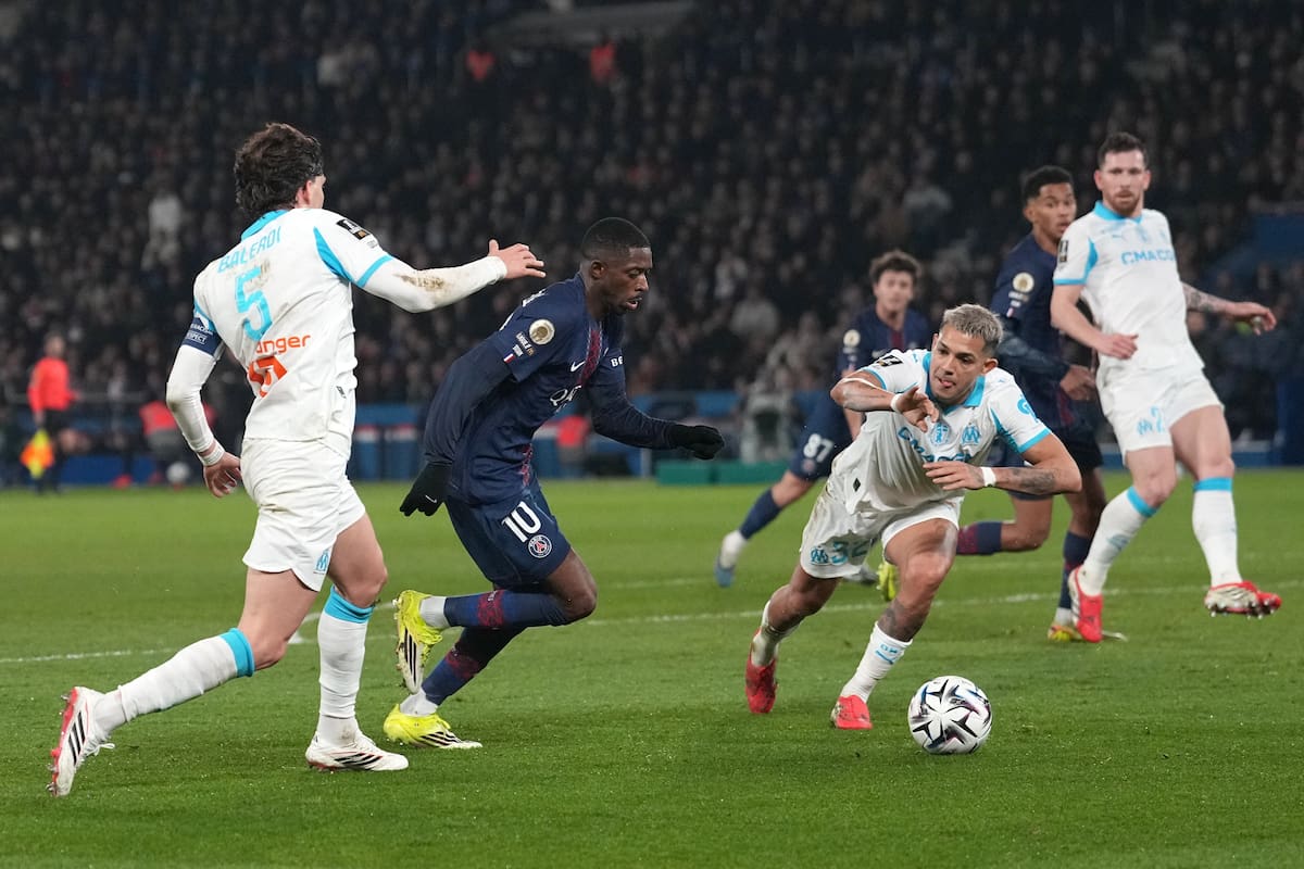 Tres protagonistas de la noche: Dembélé, en el centro, intenta escapar a la marca de los argentinos Balerdi y Medina (AP Photo/Thibault Camus)