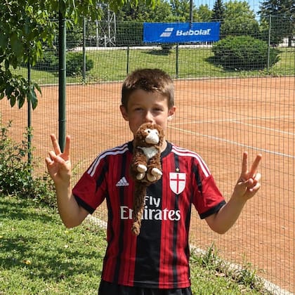 Tresoldi con la camiseta de Milan cuando era chico, junto a otra de sus pasiones: el tenis