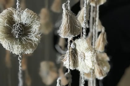 Detalle de las guirnaldas, con flores y pompones, que integran la instalación textil