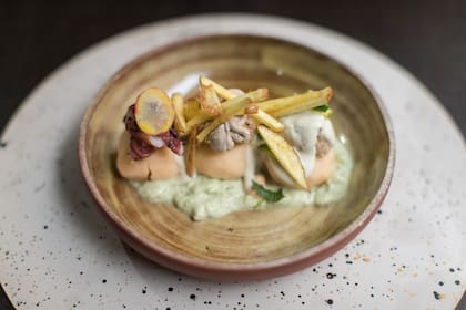Trío de papa amarilla con pulpo, atún y langostinos, ají amarillo y dressing de aceitunas verdes y negras sobre palta.