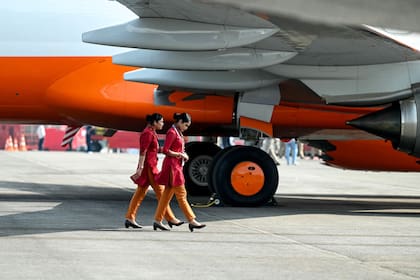 Tripulantes de un vuelo de Air India Express caminan frente a un Boeing 737-8