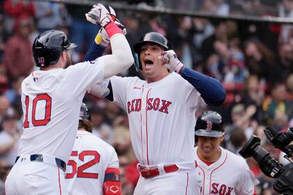 Triston Casas (centro), de los Medias Rojas de Boston celebra tras impactar un jonrón de tres carreras que también remolcó a Trevor Story (10), y Masataka Yoshida (derecho al fondo), en el primer juego de la doble tanda ante los Mellizos de Minnestoa, el domingo 22 de septiembre de 2024, en Boston. (AP Foto/Michael Dwyer)