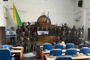 Tropas de la Brigada Golani de las FDI posan con una bandera israelí en el interior del edificio del Parlamento de Gaza, en la calle principal Omar Al-Mukhtar de la ciudad de Gaza, tras tomar el lugar.
