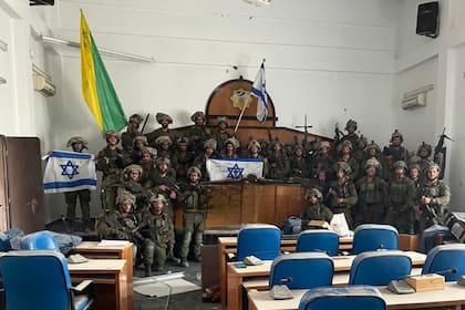 Tropas de la Brigada Golani de las FDI posan con una bandera israelí en el interior del edificio del Parlamento de Gaza, en la calle principal Omar Al-Mukhtar de la ciudad de Gaza, tras tomar el lugar.
