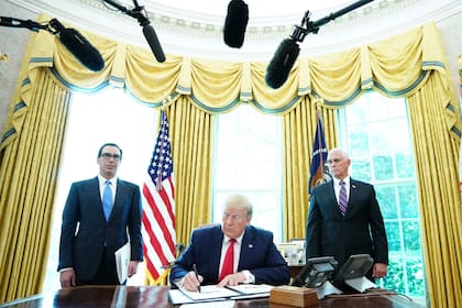 Trump firma con el vicepresidente Mike Pence (derecha) y el secretario del Tesoro de Estados Unidos, Steven Mnuchin, en la Casa Blanca, "sanciones contundentes" contra el líder supremo de Irán