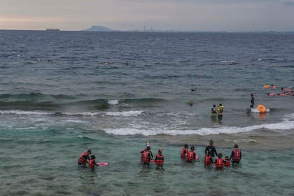 Turistas buceando en Liuqiu, una isla frente a la costa suroccidental de Taiwán, a menos de seis millas de los ejercicios de China el sábado 6 de agosto de 2022