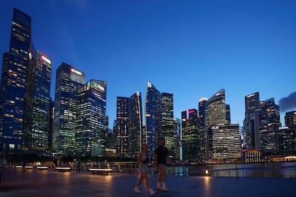 Turistas caminan ante el distrito central de negocios de Singapur