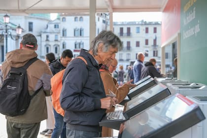 Turistas compran el ticket de 5 euros para ingresar a Venecia, el 25 de abril de 2024. (Stefano Mazzola/Getty Images)
