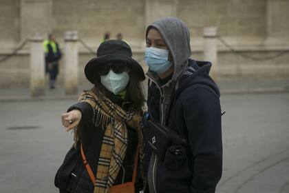 Turistas con mascarillas