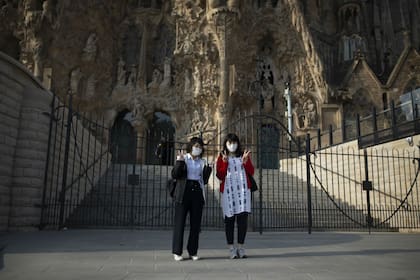 Turistas con barbijos, frente a la Sagrada Familia, que quedó cerrada y con las obras interrumpidas