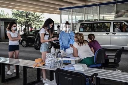 Turistas esperan recibir una prueba de coronavirus (PCR) en el cruce fronterizo griego-búlgaro en Promachonas el 10 de julio de 2020.