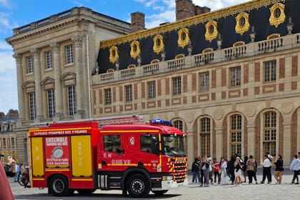 Turistas evacuados por un incendio en el Palacio de Versalles. (Foto X).