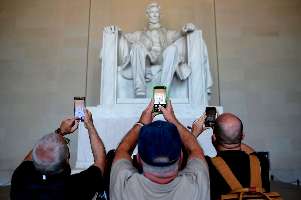 Turistas fotografían la estatua del presidente Abraham Lincoln en el Monumento a Lincoln, el martes 12 de mayo de 2026, en Washington. (Foto AP/Rahmat Gul)