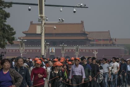 Turistas haciendo fila para visitar el mausoleo de Mao en Pekín, debajo de un poste que sostiene once cámaras de vigilancia