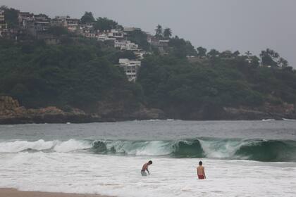 Turistas nadan en Acapulco, México, el 24 de octubre de 2023, antes de la llegada del huracán Otis. (AP Foto/Bernardino Hernández)