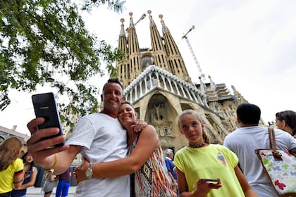 Turistas posan para una selfie frente a la Basílica de la Sagrada Familia, en Barcelona