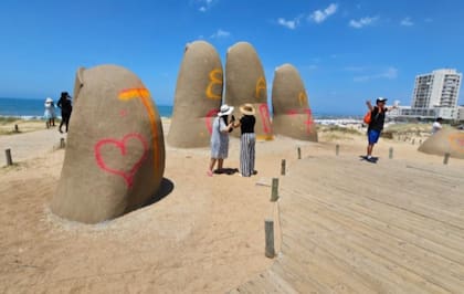 Turistas se sacan fotos con la escultura vandalizada