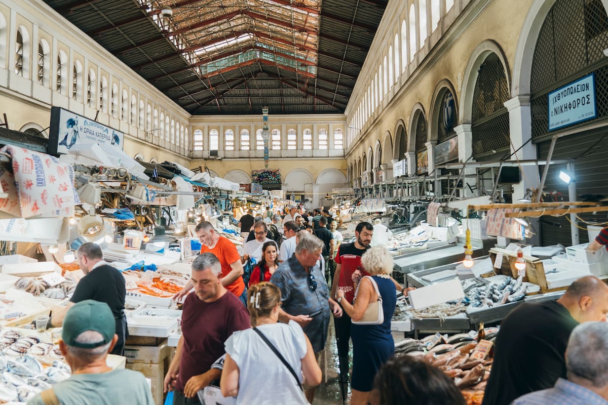 Turistas y ciudadanos compran pescado en el mercado central de Atenas, el 9 de septiembre de 2023. Es una de las economías europeas de más rápido crecimiento y, aunque los inversores y los turistas acuden en masa al país, los griegos aún recuerdan las medidas de austeridad.