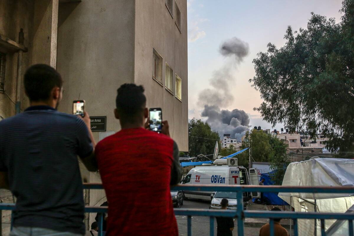 Two Palestinians at Al Shifa Hospital in Gaza City filming the bombing of Gaza, on Oct. 9, 2023. Social media is full of false and misleading posts. The rise in A.I. is making it worse, and the trust in traditional news sources has declined. (Samar Abu Elouf/The New York Times)