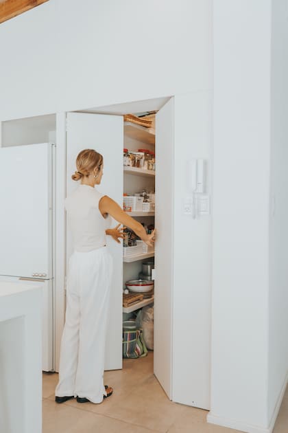Localizada na lateral da cozinha, o espaço de armazenamento foi aumentado significativamente, sem sobrecarregar visualmente o ambiente.