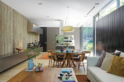 Ubicado en el centro, el comedor diario, con lámpara colgante ‘Manuela’ (Doña 3D), sillas ‘Buenamoza’ en petiribí (Bull Buenos Aires) y mesa de mármol. Sofá con funda de tussor crudo y mesa en Petiribí (todo, Estudio MMS).