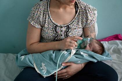 Una mujer sostiene el respirador de asistencia para su bebé en un hospital de Kiev, Ucrania