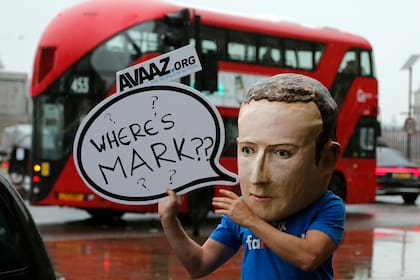Un activista con una máscara de Mark Zuckerberg pide su presencia frente al Parlamento británico