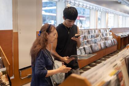 Un adolescente analiza los vinilos que se ofrecen en la librería y disquería Zivals