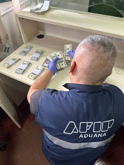 Un agente de la Aduana cuentan los 93.700 dólares secuestrados en Misiones