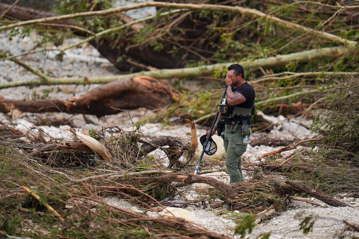 Un agente de la policía del condado hace una pausa mientras busca en las orillas del río Guadalupe cerca de Camp Mystic, tras una inundación repentina en la zona, el sábado 5 de julio de 2025, en Hunt, Texas.