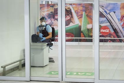 Un agente de la policía uruguaya, con máscara y guantes en el Aeropuerto de Carrasco
