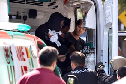 Un agente del grupo especial de la Policía de la Ciudad sostiene al bebé en el interior de la ambulancia