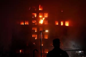 Un agente observa el edificio en llamas, en el barrio de Campanar, a 22 de febrero de 2024, en Valencia, Comunidad Valenciana (España). Un incendio de grandes dimensiones ha arrasado un edificio de 14 plantas en el barrio valenciano de Campanar