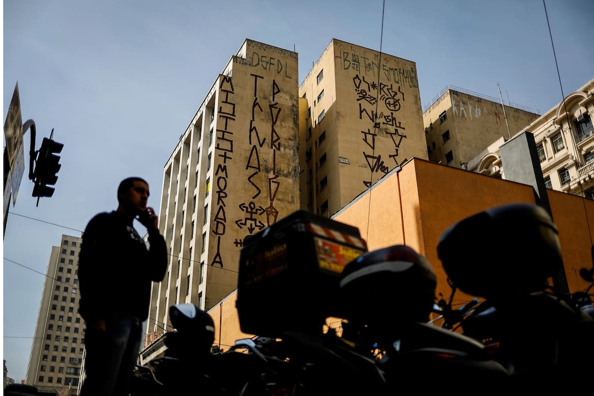 Un "pichador", un artista de graffiti que marca edificios y monumentos con fuentes angulares y rúnicas, pinta su firma personal, llamada "pichacao", encima de un edificio de apartamentos, en Sao Paulo