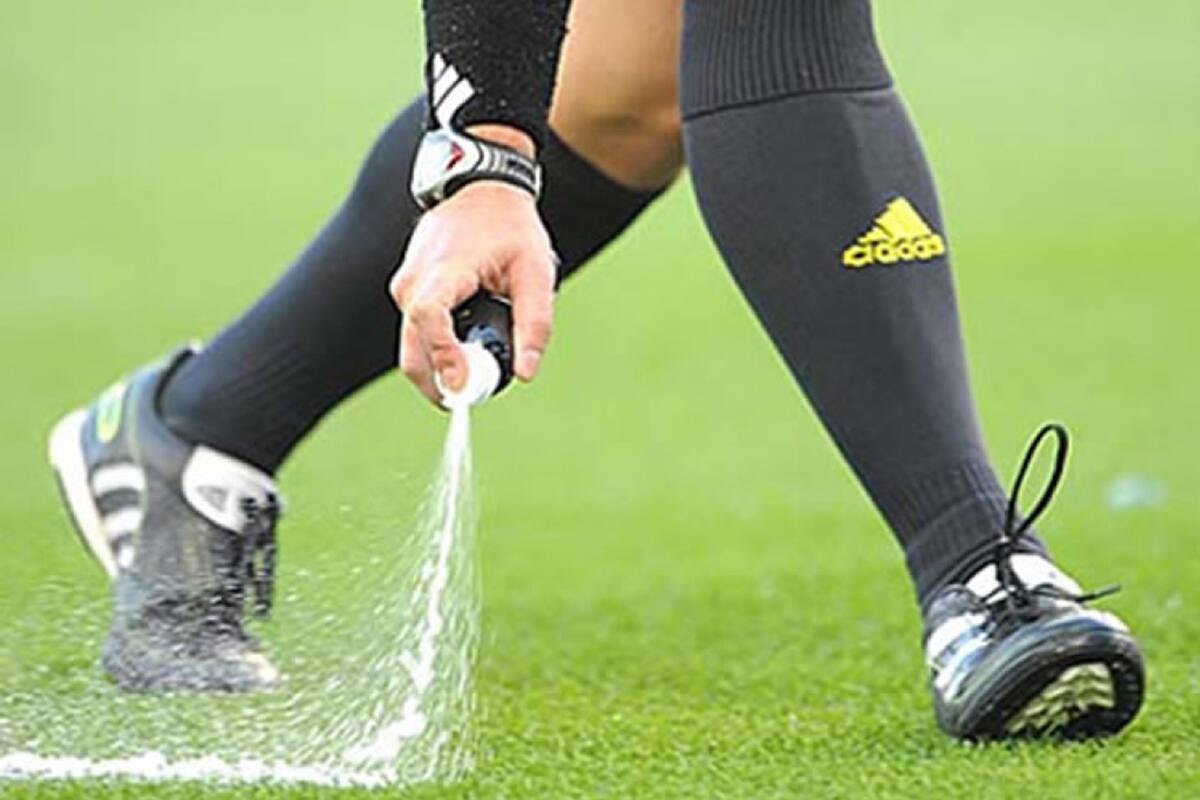 Un árbitro se ayuda con el aerosol para marcar la distancia reglamentaria en un tiro libre